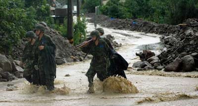 圖為救援官兵冒雨參與抗洪搶險。